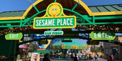 Entrance gate to Sesame Place San Diego, decorated in green and yellow with Big Bird's face above the sign.