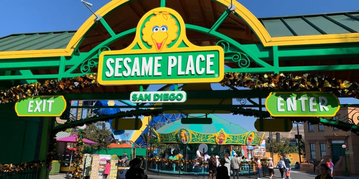 Entrance gate to Sesame Place San Diego, decorated in green and yellow with Big Bird's face above the sign.