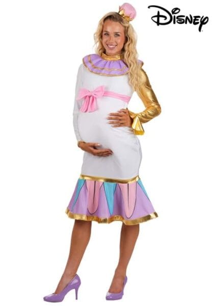 A smiling woman in a colorful, frilly Disney Mrs. Potts costume with gold, pink, and purple details poses, cradling her pregnant belly. She wears purple heels and has long blond hair, standing against a white background with the Disney Costumes logo.