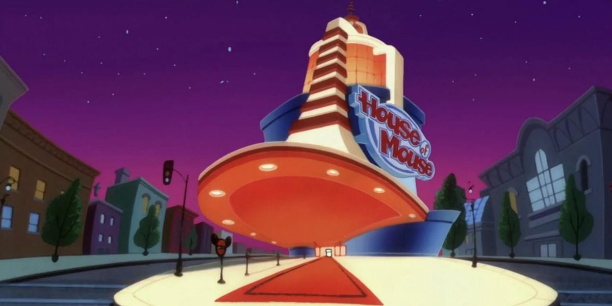 A brightly lit, futuristic house of mouse stands at night with a large sign, featuring a sweeping red carpet entrance and surrounded by city streets and buildings beneath a vibrant purple sky.