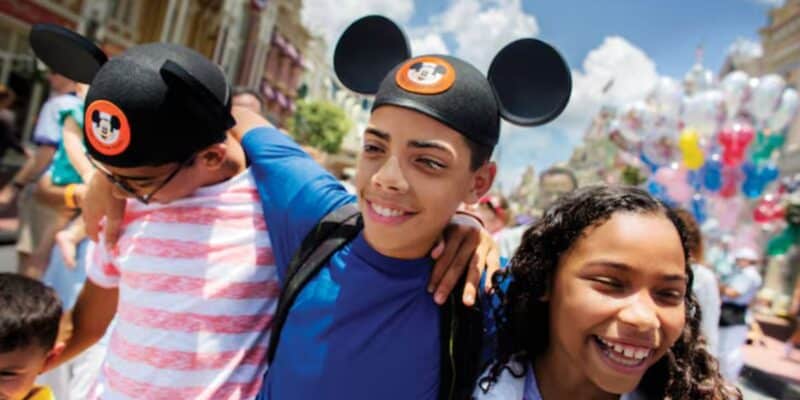 three young guests walk down main street in disney world's magic kingdom