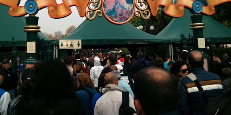 A crowd of people waits in line at a security checkpoint at Disneyland Paris Resort