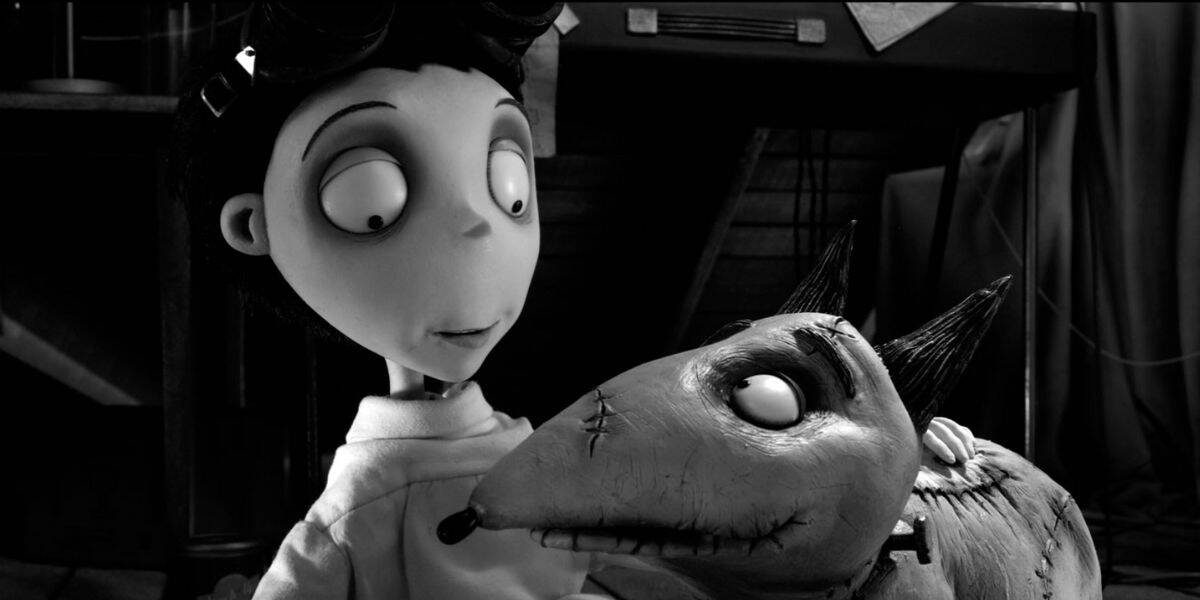 A wide-eyed animated boy in a white shirt holds a stitched-up, zombie-like dog in a black-and-white scene, capturing a gothic or spooky atmosphere reminiscent of classic Disney animation.