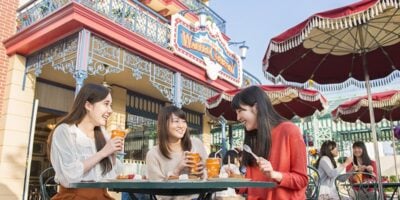Female guests eat outside Great American Waffle Co. at Tokyo Disneyland