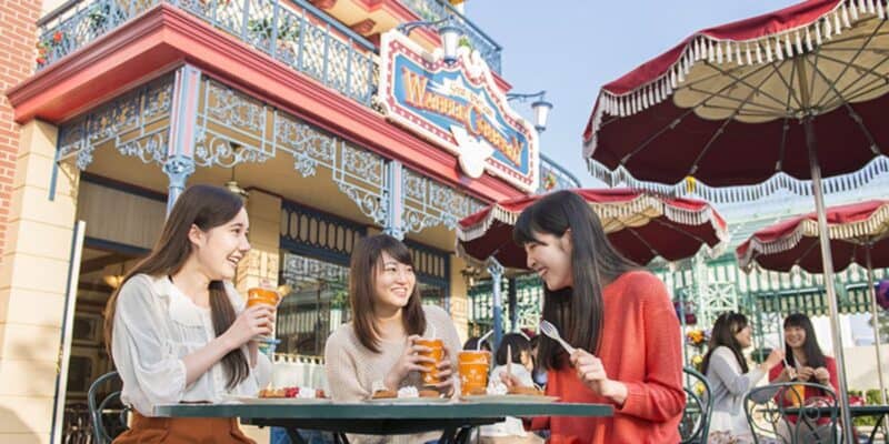 Female guests eat outside Great American Waffle Co. at Tokyo Disneyland