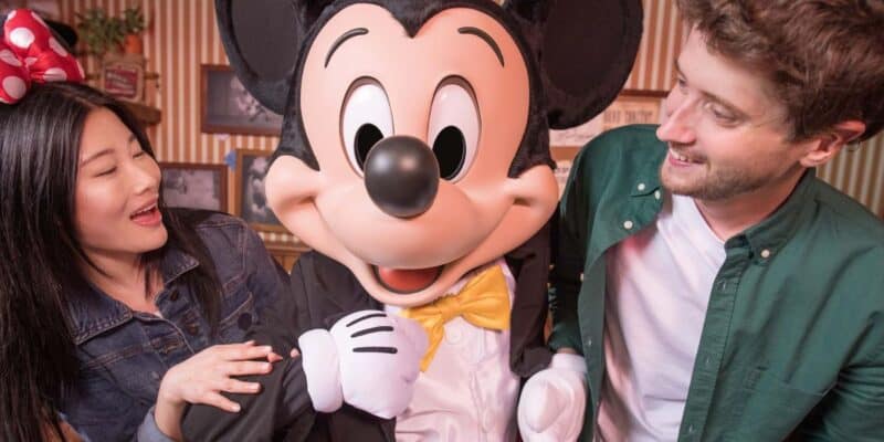 A woman and man smiling and posing with Mickey Mouse at Studio D at Disneyland Paris Resort