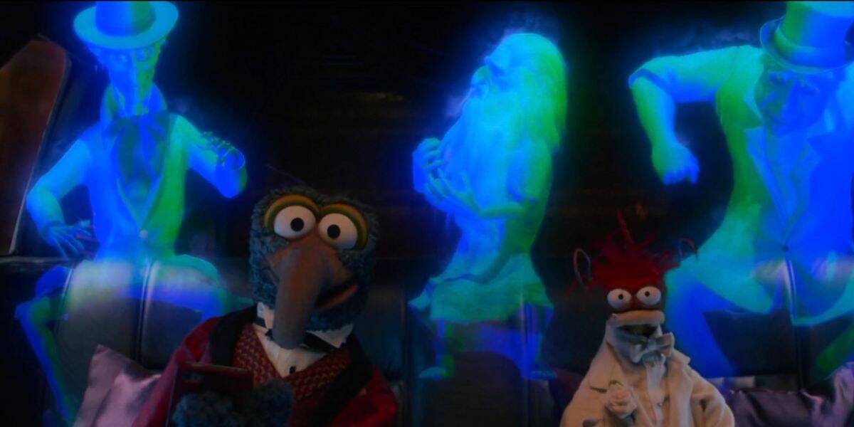 Gonzo and Pepe the King Prawn sit on a couch, looking surprised, as three glowing blue-green ghostly figures in Victorian clothing appear behind them in this colorful and animated Disney scene.