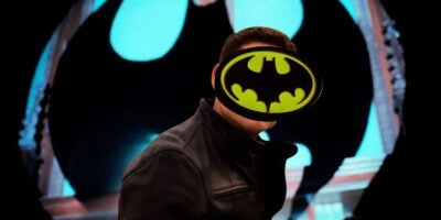 Mixed image: front, Tom Brittney in 'Grantchester' with a Bat-logo covering his face, and the Bat-signal from 'Batman' (1989) behind him