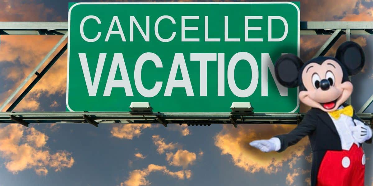 A large green road sign reads "CANCELLED VACATION" against a sunset sky. A costumed Mickey Mouse character stands to the right, smiling and gesturing toward the sign as Disney World vacations gets canceled left and right.