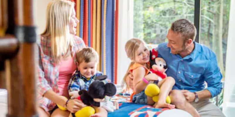 family sitting on bed together at one of disney world's hotels