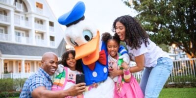 Donald Duck takes a selfie with Disney hotel guests