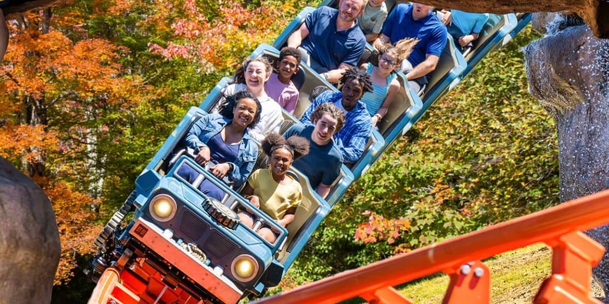 Guests on a roller coaster at Dollywood during autumn