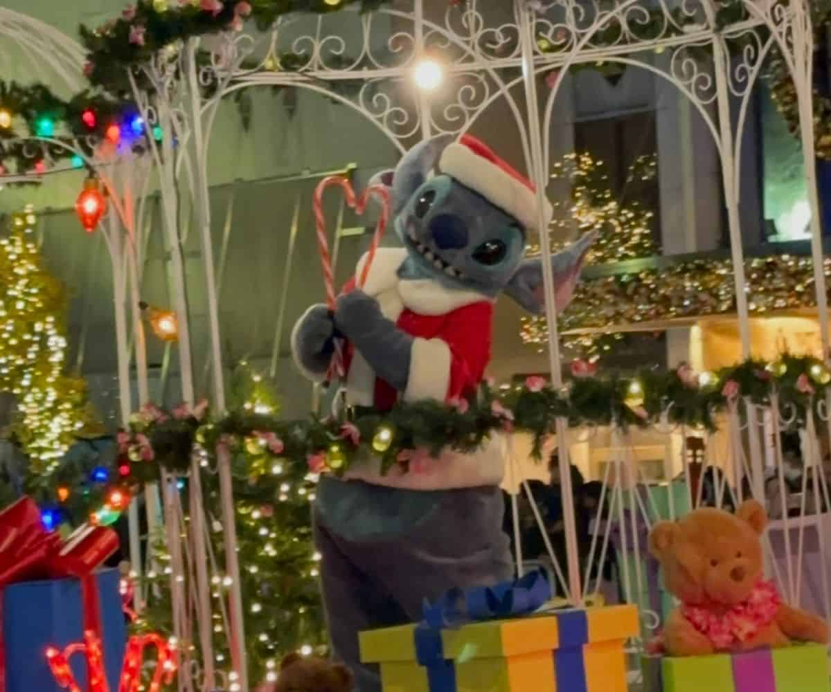 Stitch in a Santa suit waves candy canes in the Magnificent Mile Lights Festival Parade