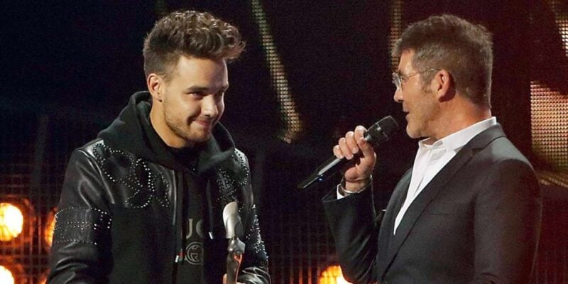 On stage at Universal Studios, a host chats with the crowd while a performer beams, holding his Best Show award.