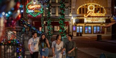 guests walk through Universal Studios Florida during Christmastime