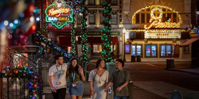 guests walk through Universal Studios Florida during Christmastime