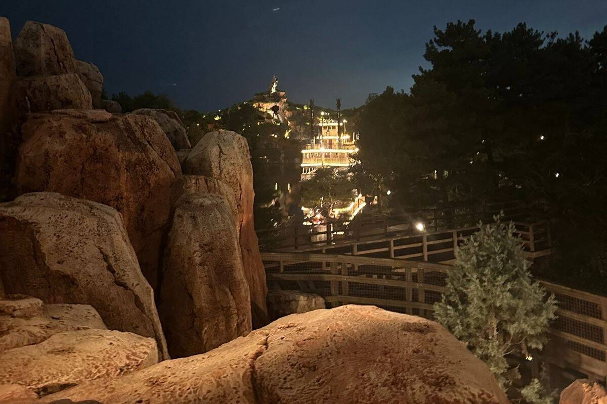 The Mark Twain Riverboat and Splash Mountain at Tokyo Disneyland, at night.