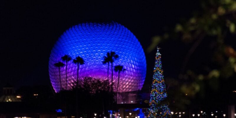 Spaceship Earth glowing blue with Christmas tree in Disney World's EPCOT park