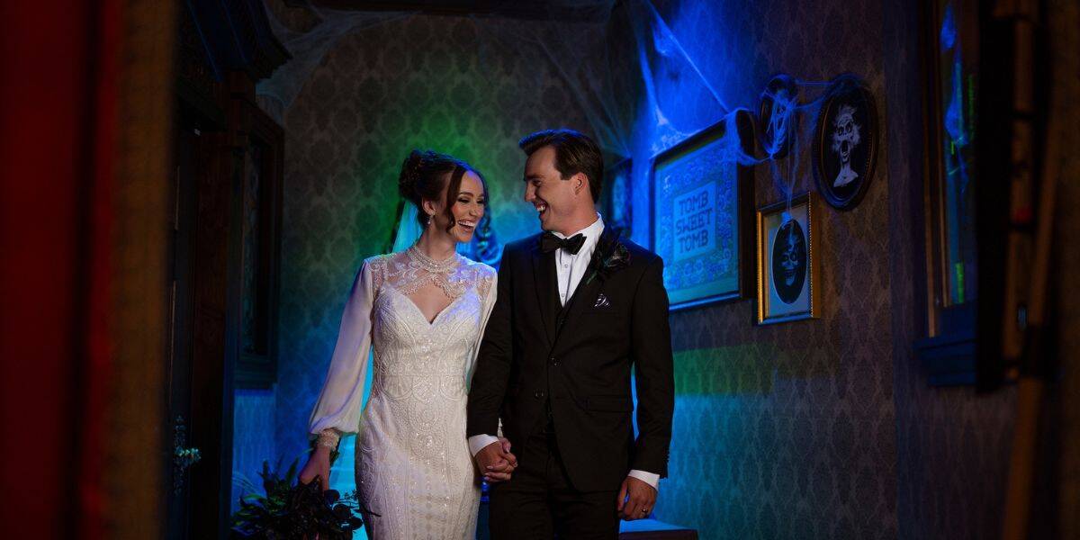 Newlyweds share a magical moment in a moody, vintage hallway with eerie Disney Cruise Line vibes and haunted mansion decor.