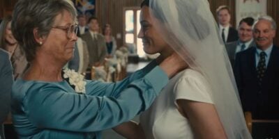 An older woman beams through happy tears at a bride in a sparkling white gown and veil inside a grand, Disney-style chapel.