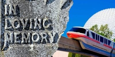 A gravestone inscribed "In Loving Memory" sits near the Epcot monorail and the iconic Spaceship Earth dome inside Disney World.