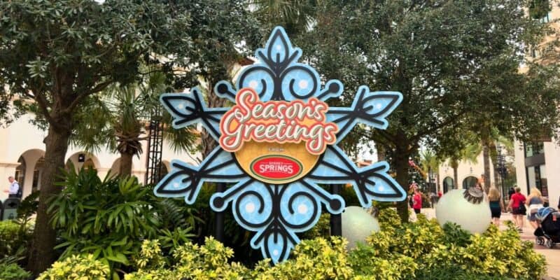 Festive "Seasons Greetings" sign with snowflakes, greenery, and ornaments dazzles Disney Springs—perfect for holiday photos!.