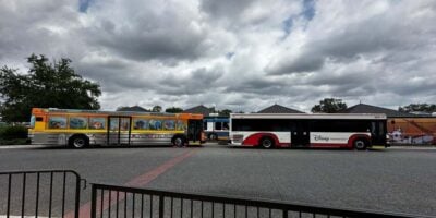 Two Walt Disney World Resort transportation buses parked outside Magic Kingdom