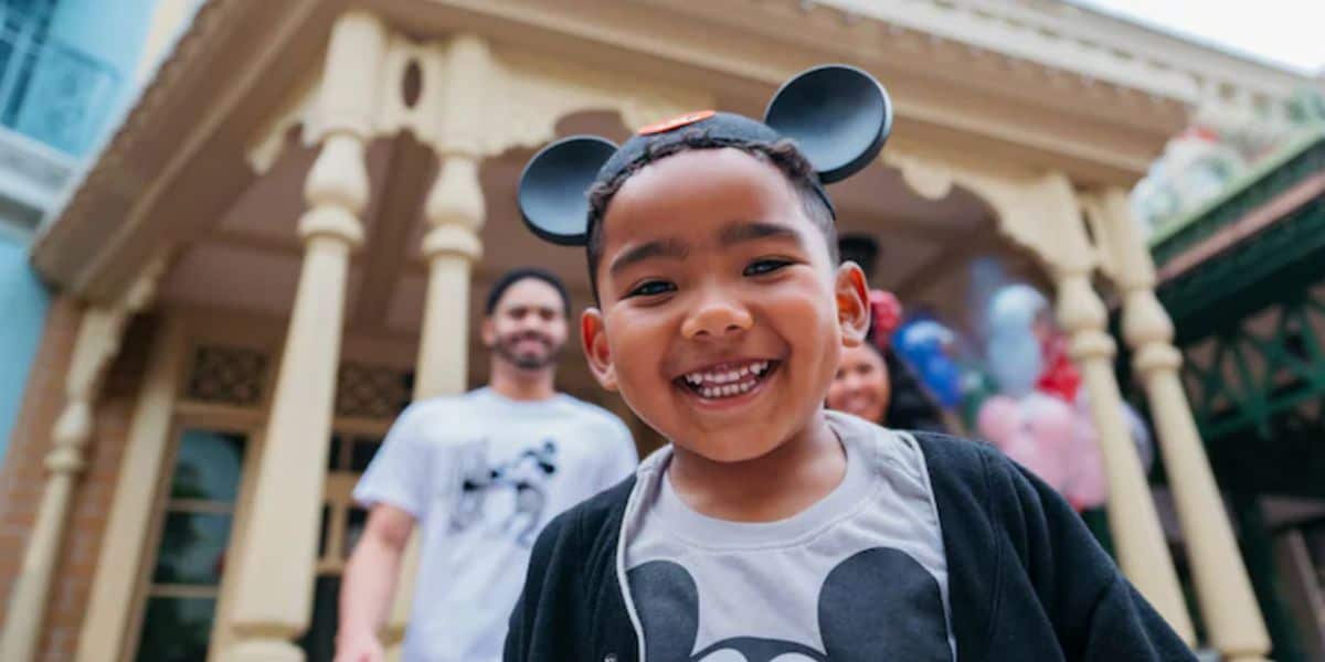 young guest smiling while wearing mickey ears at Disney World