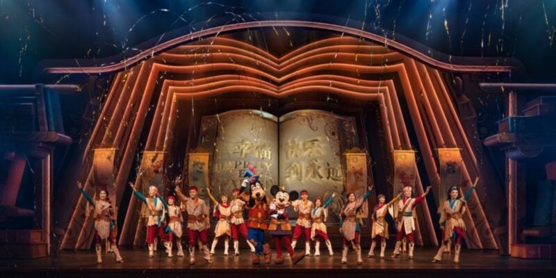 Mickey Mouse and Goofy onstage with dancers during a performance of Mickey's Storybook Adventure