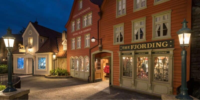 Nighttime at EPCOT's Norway Pavilion, with The Fjording shop aglow and colorful Nordic façades showcasing enticing park merchandise.