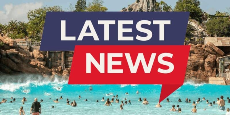Guests making a splash in the wave pool at the Typhoon Lagoon water park, with “Latest News” highlighted on vibrant, bold banners inside of this Disney World park.