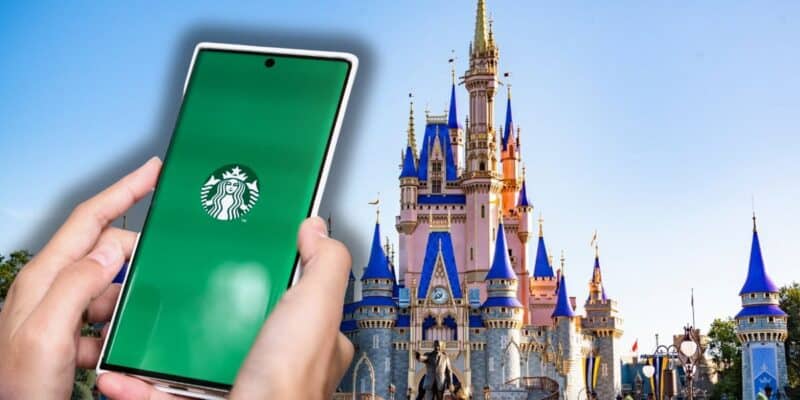 A guest using the Starbucks app on their phone with Cinderella Castle in the background under bright, sunny skies at Disney World inside Magic Kingdom for the 2026 Dining Plan.