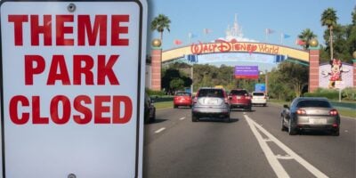 A "Theme Park Closed" sign greets cars by the Walt Disney World entrance, signaling a rare closure for incoming Disney fans.