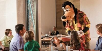 Goofy welcomes a happy family at their table during character dining, creating magical moments at a Disney park restaurant. Four Seasons Orlando Walt Disney World ownership change