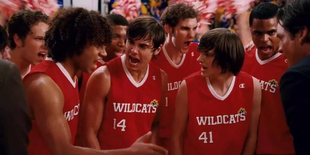 Wildcats basketball team huddles mid-game, strategizing with high energy like a live halftime show at a theme park arena.