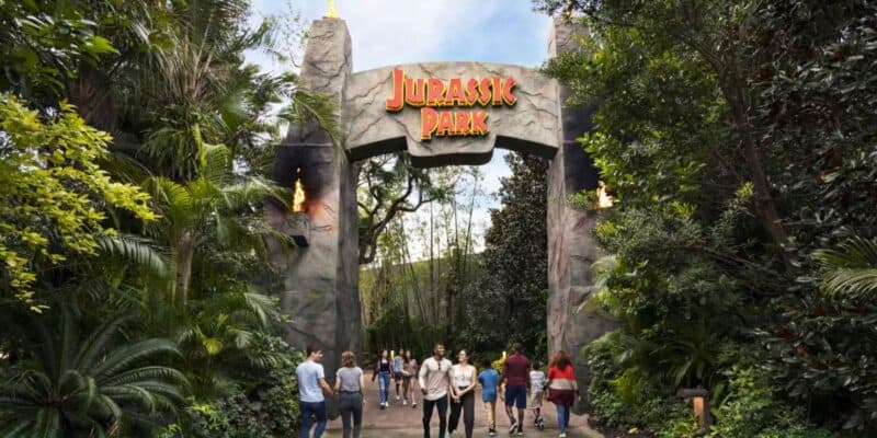 guests pass Jurassic Park gate entrance in Universal Orlando's Islands of Adventure park