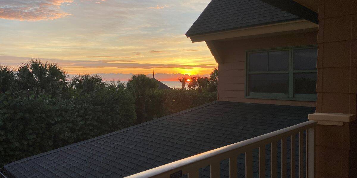 Sunrise over the ocean at Disney's Forgotten Resort, seen from a balcony—an enchanting New Year’s Eve scene for Disney fans.