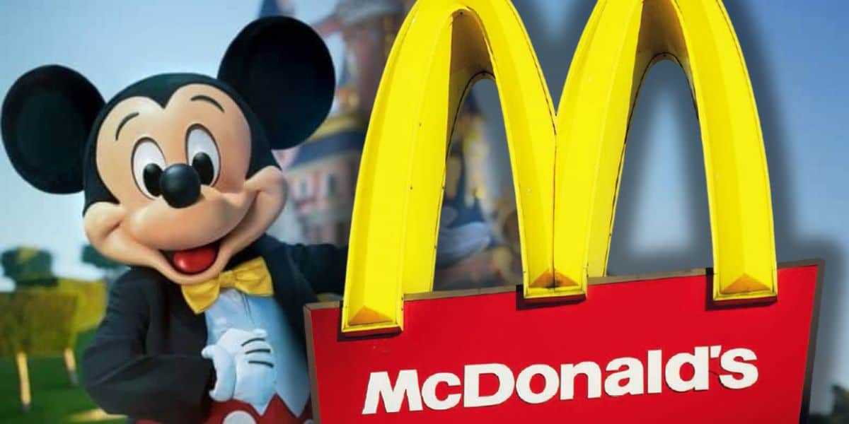 Mickey Mouse poses beside a giant McDonald's golden arches sign, blending Disney magic with familiar fast food fun.