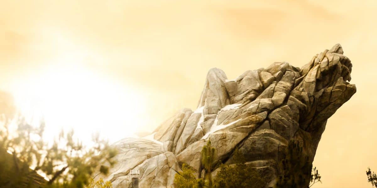 Howling Wolf Rock, surrounded by trees and a golden sky—an iconic photo spot in the Disney Park’s Kids' Area.