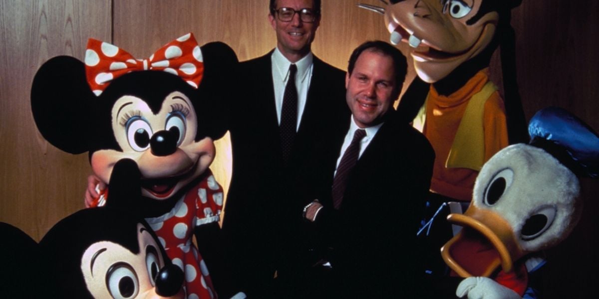 Michael Eisner and Frank Wells pose with Mickey and Minnie Mouse, Goofy, and Donald Duck
