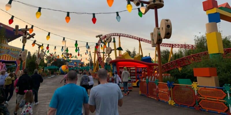 Guests walking through Toy Story Land at sunset.
