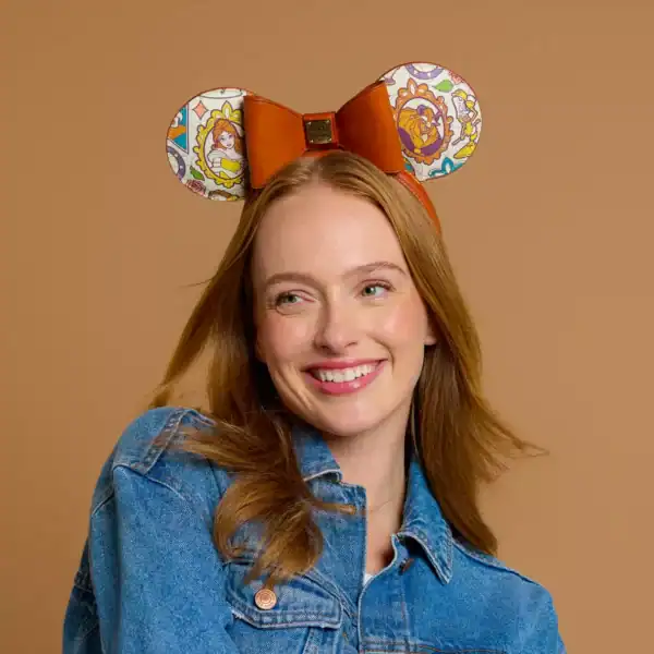 Guest showing off limited-edition Beauty and the Beast mouse ears while exploring the parks in a stylish denim jacket.