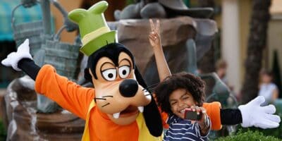 A young guest takes a picture with Goofy at Disneyland Paris