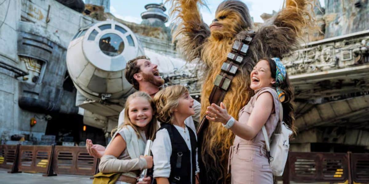 disney family poses with chewbacca at galaxy's edge in disney's hollywood studios park