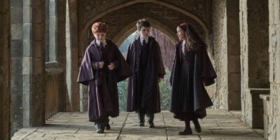 Ron Weasley, Harry Potter, and Hermione Granger in the hallways of Hogwarts