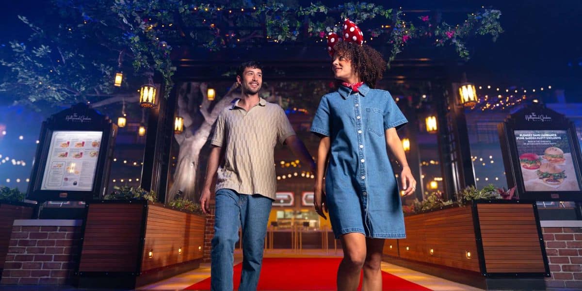 Two guests walk through The Hollywood Garden Restaurant at Disney Adventure World