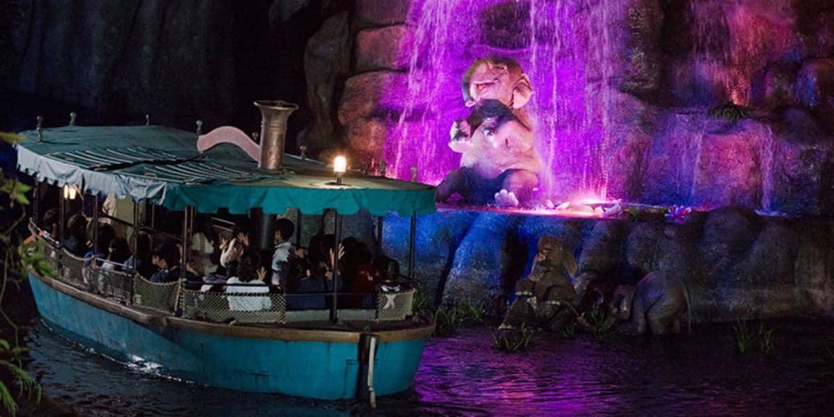 Guests pass by a baby elephant at night on Jungle Cruise: Wildlife Expeditions