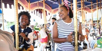 a mom and her son ride the prince charming carousel in disney world's magic kingdom park