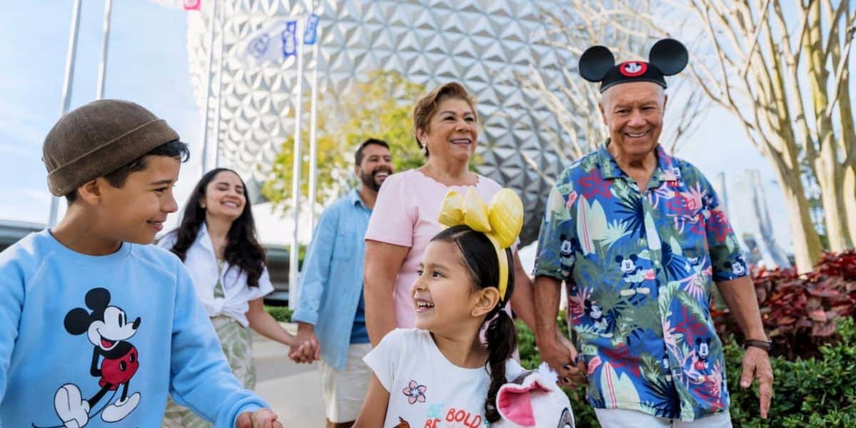 a Disney family strolls through EPCOT with Spaceship Earth in the background