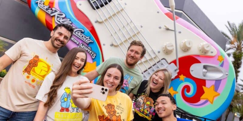 a group takes a selfie in front of rock n roller coaster starring the muppets guitar in disney's hollywood studios